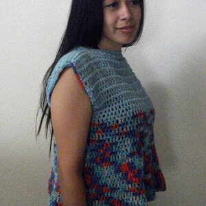 May include: A sleeveless crochet top with a blue, red, and white color pattern. The top has a loose fit and a round neckline.