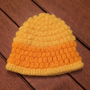 Puede incluir: Un gorro de punto con un dise&ntilde;o degradado de amarillo y naranja. El gorro est&aacute; hecho con un punto texturizado que crea una superficie abultada.