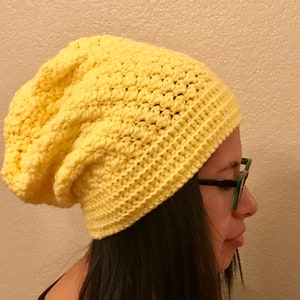 Puede incluir: Un gorro de punto amarillo con un ajuste holgado.