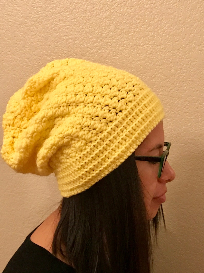 Puede incluir: Un gorro de punto amarillo con un ajuste holgado.
