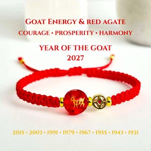 Könnte beinhalten: Ein rotes geflochtenes Armband mit einer zentralen roten Achatperle mit goldenem Ziegenemblem, einem münzförmigen Goldanhänger und kleinen goldenen Abstandshaltern. Text: GOAT ENERGY & RED AGATE, COURAGE • PROSPERITY • HARMONY, YEAR OF THE GOAT, 2027, 2015 • 2003 • 1991 • 1979 • 1967 • 1955 • 1943 • 1931.