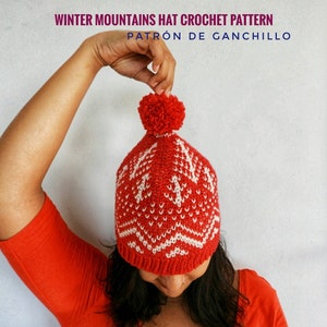 Puede incluir: Un gorro de punto rojo y blanco con un pomp&oacute;n blanco en la parte superior. El gorro presenta un patr&oacute;n geom&eacute;trico. El texto "WINTER MOUNTAINS HAT CROCHET PATTERN PATR&Oacute;N DE GANCHILLO" est&aacute; en la parte superior de la imagen.