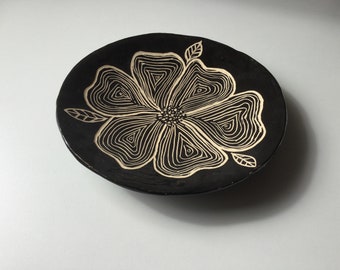 Round black craft ceramic cut with sgraffite flower