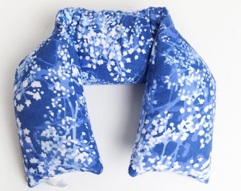 May include: A blue and white floral patterned neck pillow. The pillow is shaped like a U and is designed to support the neck.