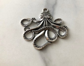 May include: Silver-toned octopus charm with detailed tentacles and a textured body. The charm has a loop at the top for attaching to jewelry or other crafts.