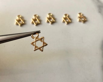 May include: Six gold-colored Star of David charms with a loop for attaching to jewelry or other crafts.
