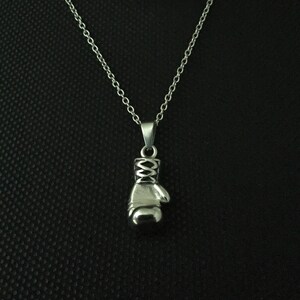 May include: A silver chain necklace with a silver boxing glove pendant.