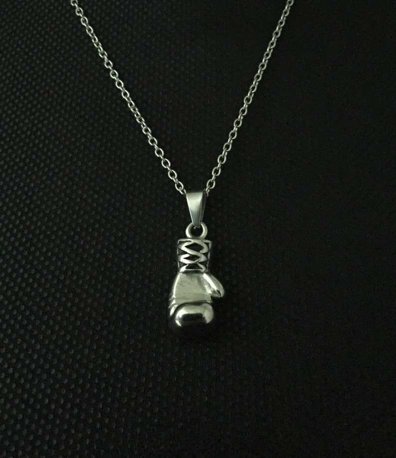 May include: A silver chain necklace with a silver boxing glove pendant.
