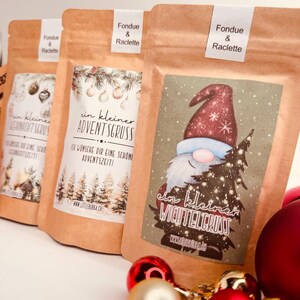 May include: Three brown paper bags labelled "Fondue & Raclette" with festive holiday designs. One bag features a gnome holding a Christmas tree, another has text "ein kleiner ADVENTSGRUSS", and the third has text "WEWNACHT SERUS".