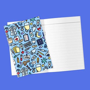 Könnte beinhalten: Ein Notizbuch mit blauem Einband, verziert mit medizinischen Illustrationen wie Stethoskopen und Spritzen. Auf dem Einband stehen die Worte "HAND OVER" und "I'M A NURSE". Das Notizbuch ist zu einer leeren, linierten Seite geöffnet.