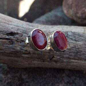 Peut inclure: Une paire de boucles d'oreilles en argent avec des pierres pr&eacute;cieuses de rubis rouges de forme ovale.