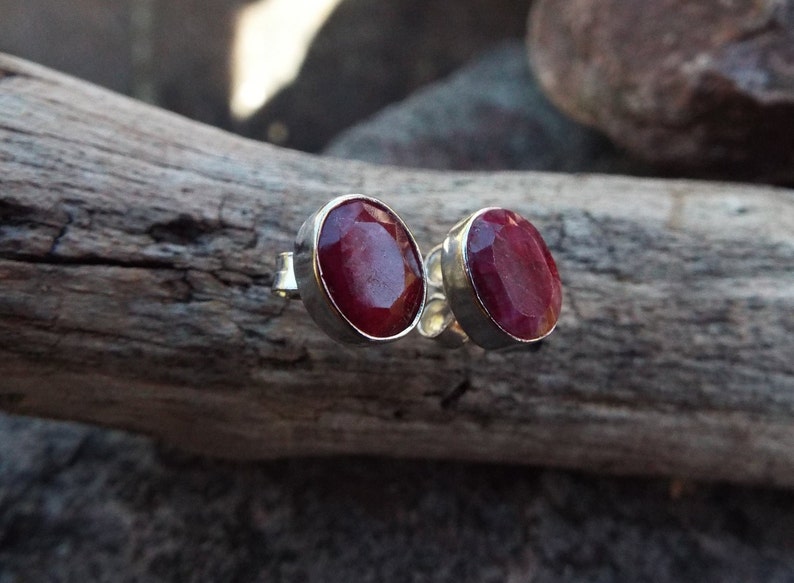 Peut inclure: Une paire de boucles d'oreilles en argent avec des pierres pr&eacute;cieuses de rubis rouges de forme ovale.