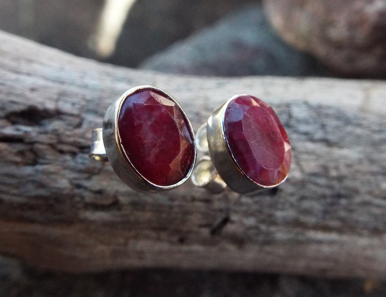 Peut inclure: Une paire de boucles d'oreilles en argent avec des pierres pr&eacute;cieuses de rubis rouges de forme ovale.