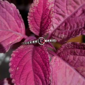 Könnte beinhalten: Ein Set aus drei Keramikbechern mit gesprenkelter, matter Oberfläche. Die Becher sind in Creme-, Hellgrau- und Dunkelgrautönen gehalten. Jeder Becher hat ein schlichtes, minimalistisches Design.