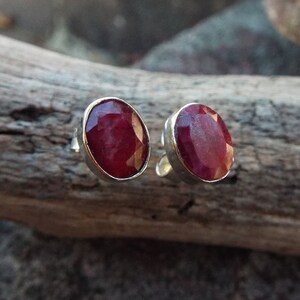 Peut inclure: Une paire de boucles d'oreilles en argent avec des pierres pr&eacute;cieuses de rubis rouges de forme ovale.