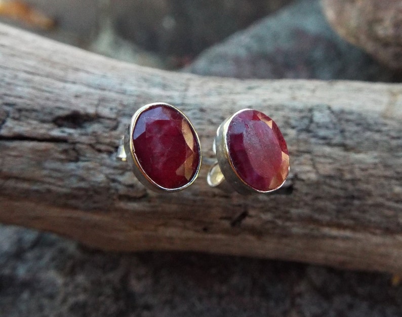 Peut inclure: Une paire de boucles d'oreilles en argent avec des pierres pr&eacute;cieuses de rubis rouges de forme ovale.