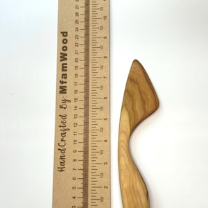 Puede incluir: Un esparcidor de madera de color marr&oacute;n claro con un mango curvo y una hoja plana, colocado junto a una regla de madera que mide 30 cm de largo y presenta el texto HandCrafted By: MfamWood impreso en el lateral.