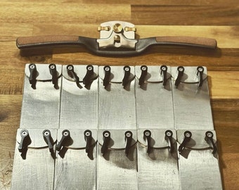 May include: A set of 12 silver metal tuning pegs with black plastic knobs. The pegs are arranged in two rows of six. The pegs are used for tuning musical instruments.