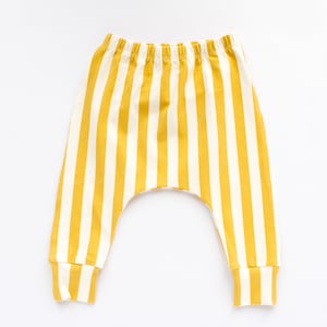 May include: Yellow and white striped baby pants with a cuffed leg.
