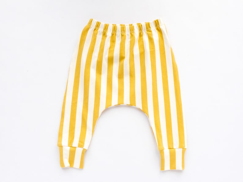 May include: Yellow and white striped baby pants with a cuffed leg.