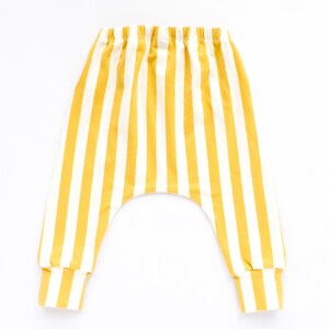 May include: Yellow and white striped baby pants with a wide elastic waistband.