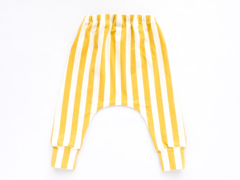 May include: Yellow and white striped baby pants with a wide elastic waistband.