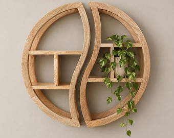 Könnte beinhalten: Ein hellbraunes Wandregal aus Holz in Form eines Yin-Yang-Symbols, bestehend aus zwei geschwungenen Abschnitten mit horizontalen Ablagen. Eine kleine grüne Hängepflanze mit panaschierten Blättern steht auf einem Regalboden und rankt herab.