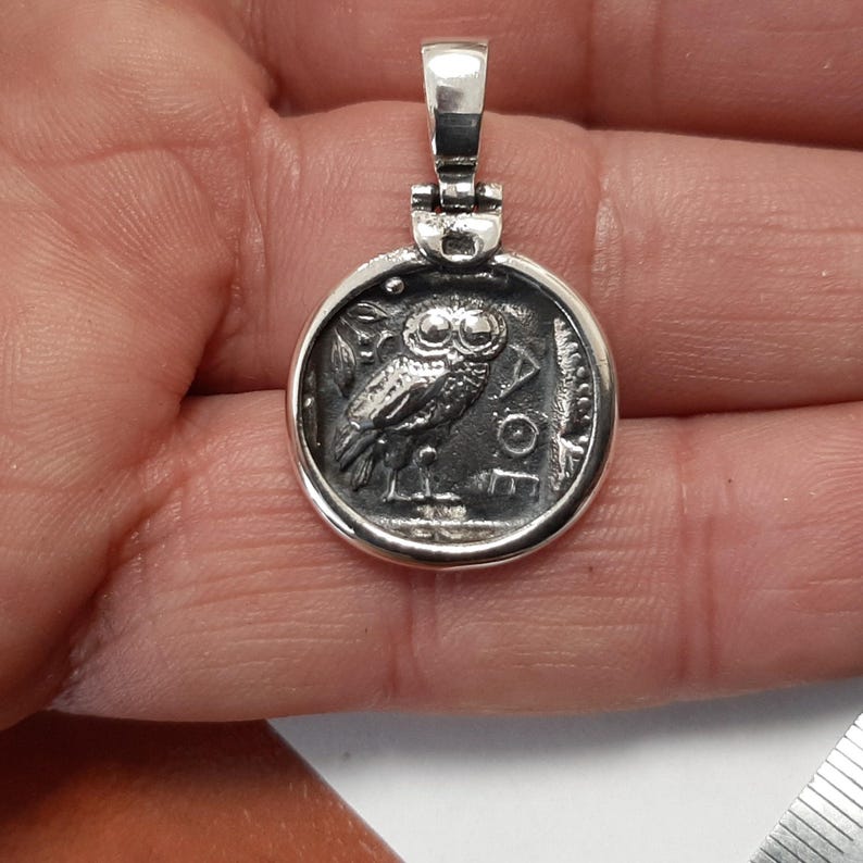 The pendant with the Owl side option in a man's hand without chain.