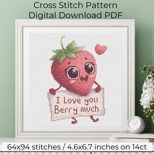 Puede incluir: Patrón de punto de cruz enmarcado con una fresa sonriente que sostiene un cartel que dice "I Love you Berry much". La fresa tiene ojos grandes y un tallo verde. El patrón mide 11,68 cm x 17,02 cm.