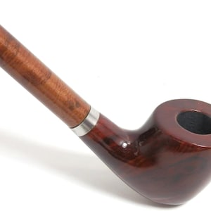 May include: A wooden smoking pipe with a long, brown stem and a dark red bowl. The stem has a silver band near the bowl.