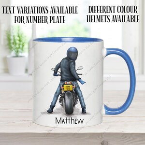 May include: A white ceramic mug with a blue rim and handle. The mug features a graphic of a person riding a motorcycle with the text "Born to be Wild" on the license plate. The name "Matthew" is printed below the graphic.