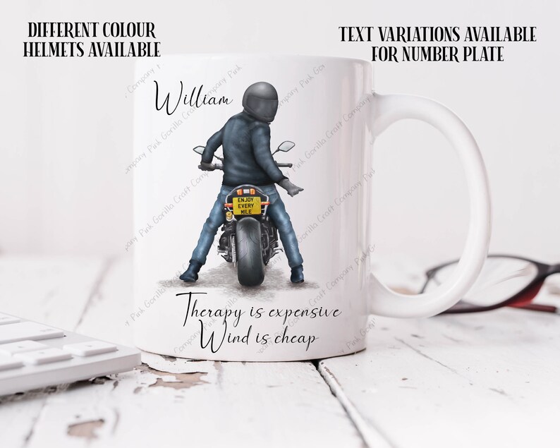 May include: White ceramic mug with a black and white illustration of a person riding a motorcycle. The mug has the text "Therapy is expensive, Wind is cheap" and "Enjoy Every Mile" on the number plate of the motorcycle.