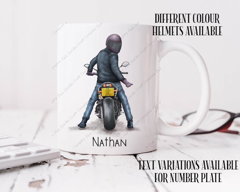 May include: White ceramic mug with a graphic of a person riding a motorcycle. The motorcycle has a yellow license plate that reads "EAT SLEEP RIDE REPEAT". The mug has a black handle and the name "Nathan" is printed on the bottom. The text "DIFFERENT COLOUR HELMETS AVAILABLE" is printed above the image and the text "TEXT VARIATIONS AVAILABLE FOR NUMBER PLATE" is printed below the image.