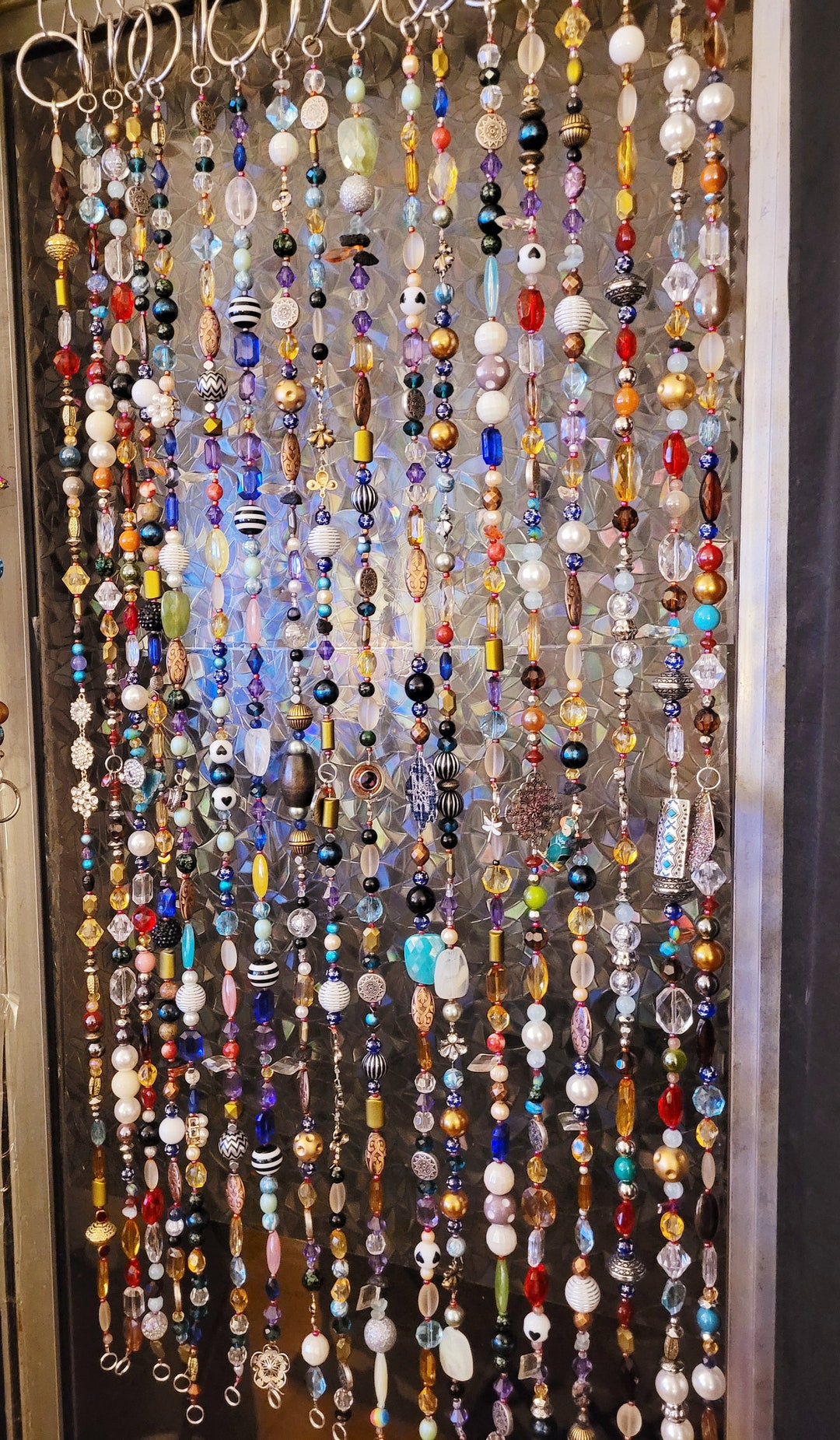 Cortina de cuentas elaborada con piedras preciosas, vidrio y