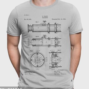 Könnte beinhalten: Ein graues T-Shirt mit einer Vintage-Patentzeichnung eines Teleskops. Die Patentnummer lautet 461.389 und das Patentdatum ist der 13. Oktober 1891. Der Text "J. PAOLI TELESCOPE" ist ebenfalls in der Zeichnung enthalten.