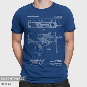May include: A blue t-shirt with a white print of a patent drawing for a firearm. The drawing shows a side view of the firearm with the text "United States Patent" and "Ingram" at the top. The text "FIG. 1" is below the drawing. The text "3,651,736" and "Mar. 28, 1972" are in the upper right corner. The text "INVENTOR Gordon B. Ingram" and "ATTORNEY Walter M.  Bollye" are at the bottom of the drawing.