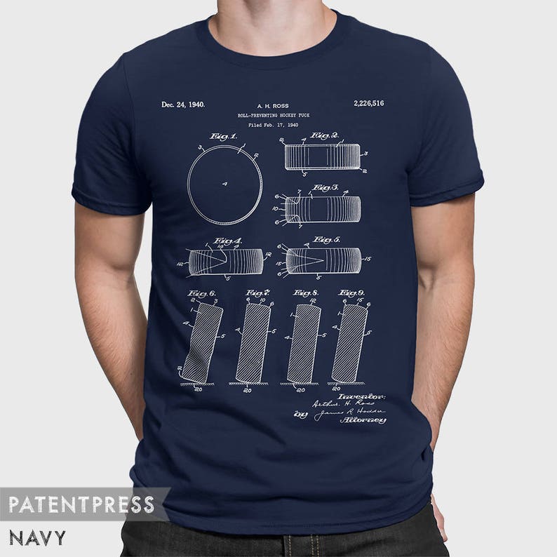 May include: A navy blue t-shirt with a white print of a patent drawing for a "Roll-Preventing Hockey Puck". The patent number is 2,226,516 and the date is December 24, 1940. The drawing shows different views of the puck.