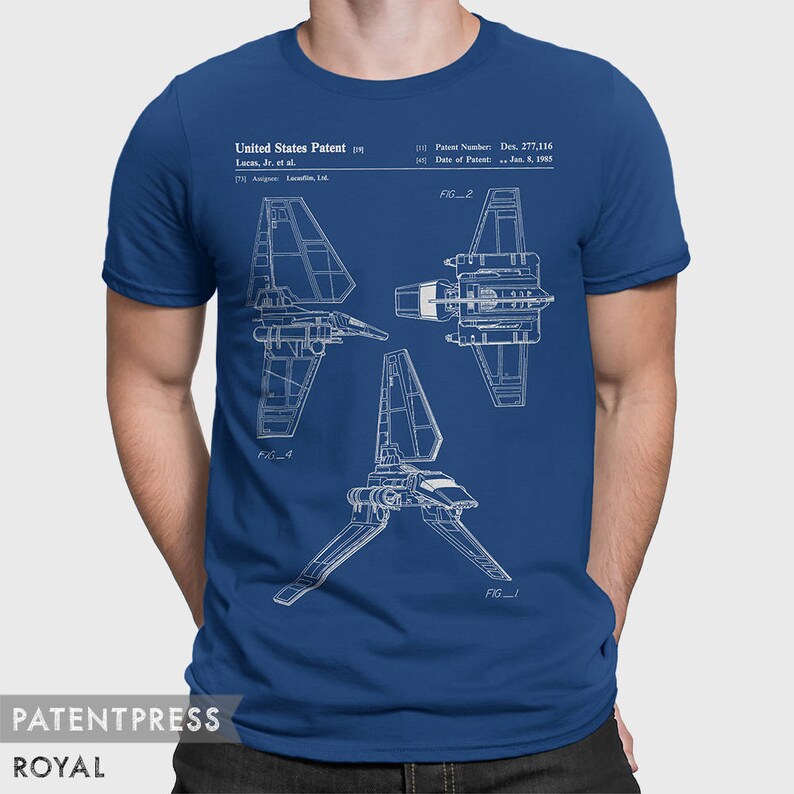 May include: A royal blue t-shirt with a white outline of a spaceship design. The design includes the text "United States Patent", "Lucas, Jr. et al.", "Patent Number: Des. 277,116", and "Date of Patent: Jan. 5, 1985".