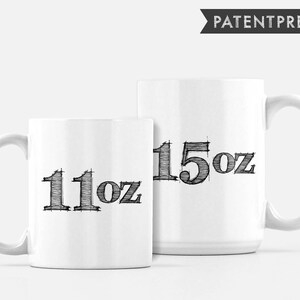 May include: Two white ceramic mugs with black text. The smaller mug says "11oz" and the larger mug says "15oz".