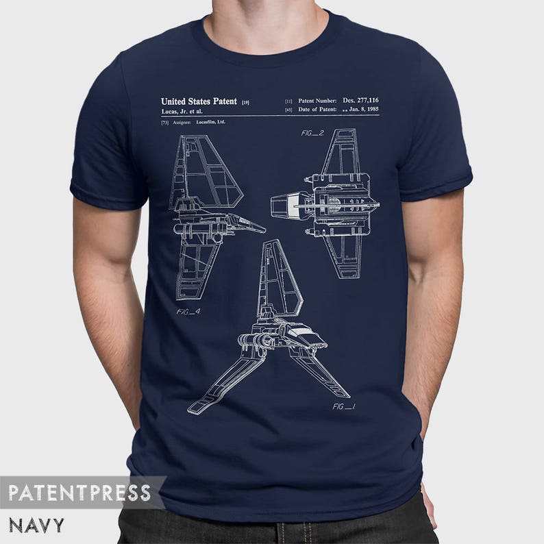May include: A navy blue t-shirt with a white print of a Star Wars X-wing fighter patent design. The patent number is Des. 277,116 and the date of patent is Jan. 8, 1985. The text "United States Patent" and "Lucas, Jr. et al." are also included in the print.