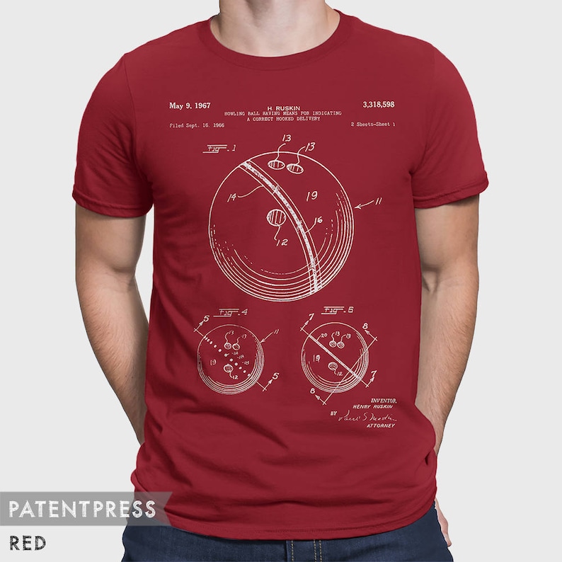 Pode incluir: Uma camiseta vermelha com uma estampa branca de um desenho de patente de bola de boliche. O n&uacute;mero da patente &eacute; 3.318.598 e a data da patente &eacute; 9 de maio de 1967. A patente &eacute; para uma bola de boliche que possui meios para indicar uma entrega correta com gancho.