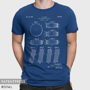 May include: A blue t-shirt with a white print of a patent for a "Roll-Preventing Hockey Puck" dated December 24, 1940. The patent drawing shows different views of the puck, with the text "A.H. Ross" and "2,226,516" printed above the drawing.