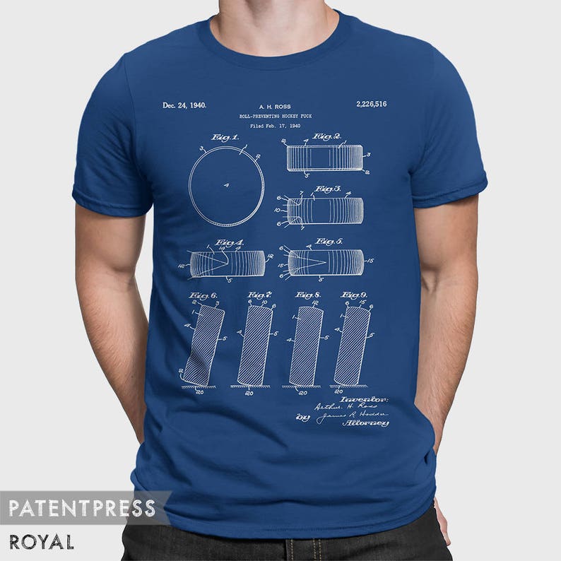 May include: A blue t-shirt with a white print of a patent for a "Roll-Preventing Hockey Puck" dated December 24, 1940. The patent drawing shows different views of the puck, with the text "A.H. Ross" and "2,226,516" printed above the drawing.