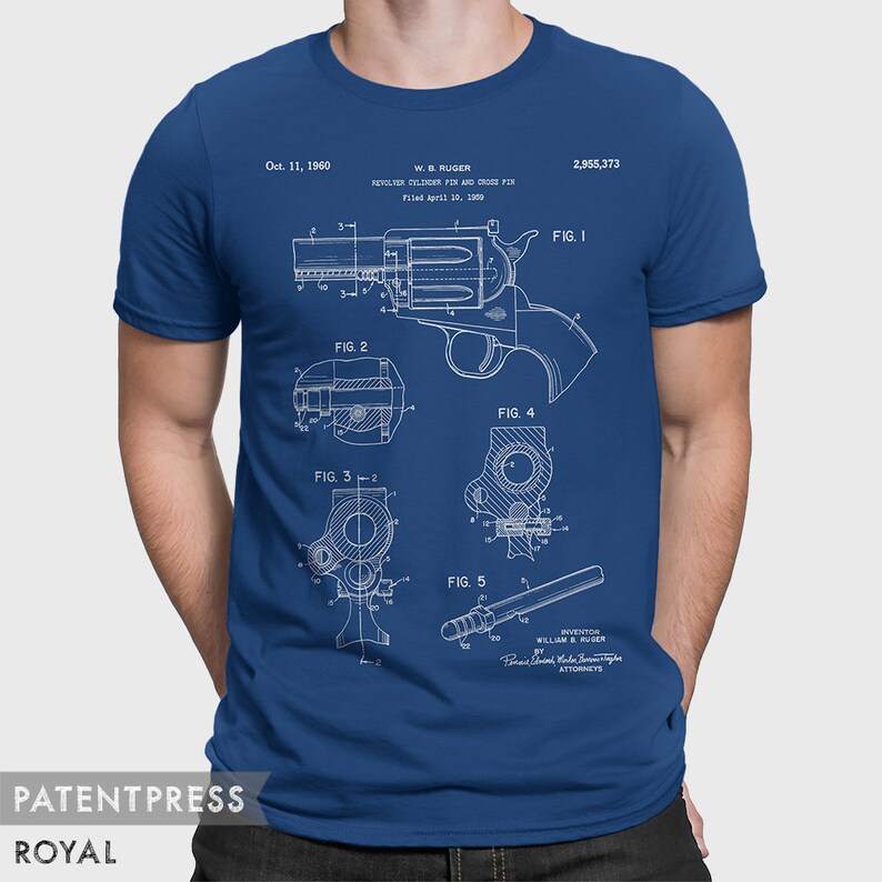 Puede incluir: Una camiseta azul con una impresi&oacute;n blanca de un dibujo de patente para un rev&oacute;lver. El dibujo de patente incluye el texto "W. B. RUGER REVOLVER COLLISION PIN AND CROSS PIN Filed April 10, 1960 2,955,373".