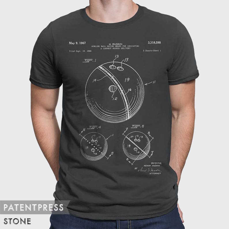 Pode incluir: Uma camiseta cinza escura com uma estampa branca de um desenho de patente de bola de boliche. O n&uacute;mero da patente &eacute; 3.318.598 e a data da patente &eacute; 9 de maio de 1967. O inventor &eacute; H. Ruskin.