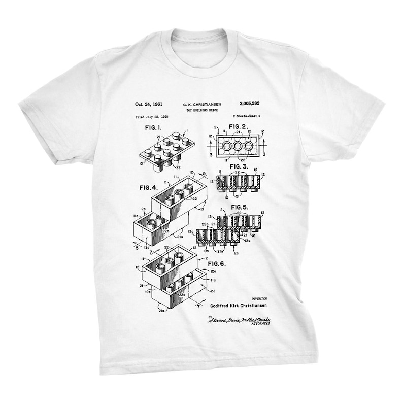 K&ouml;nnte beinhalten: Ein wei&szlig;es T-Shirt mit einem Schwarzwei&szlig;bild eines Patents f&uuml;r einen Spielzeugbausteine. Die Patentnummer lautet 3,005,282 und der Erfinder ist Godtfred Kirk Christiansen. Das Patent wurde am 20. Juli 1958 eingereicht und am 24. Oktober 1961 erteilt.
