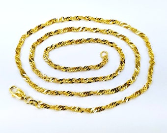 May include: A gold chain necklace with a twisted rope design. The chain is made of a shiny metal and is about 20 inches long.