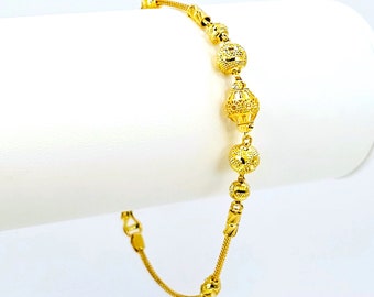 May include: A gold bracelet with a chain link design and round, textured beads.