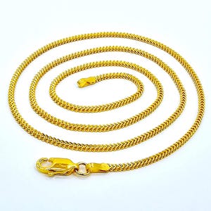 May include: A gold chain necklace with a lobster clasp. The chain is made of a series of small, interlocking links.