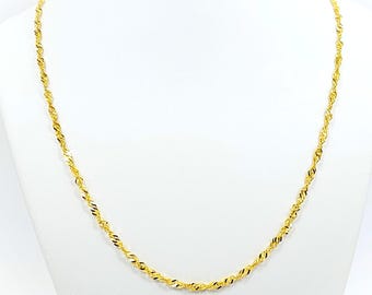 May include: A delicate gold-colored necklace with a twisted rope design. The necklace is displayed on a white mannequin, showcasing its intricate details and reflective surface. The chain is made of small, tightly wound links.